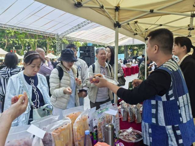 众多市民品尝购买百色田阳等地农特产品。