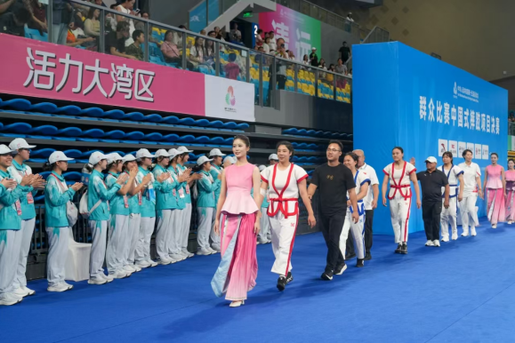 7月25日，“十五运”中国式摔跤项目决赛现场，清远职业技术学院志愿者李晓燕负责礼仪指引。清远日报记者 邱炜民 摄