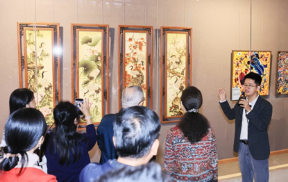 工作人员向参观者介绍广东民间工艺精品特色。