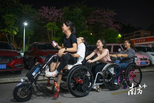 训练之余，杨晓婷与队友一同体验电动轮椅。