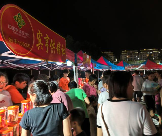 舞台周边的农产品市集烟火气十足。  