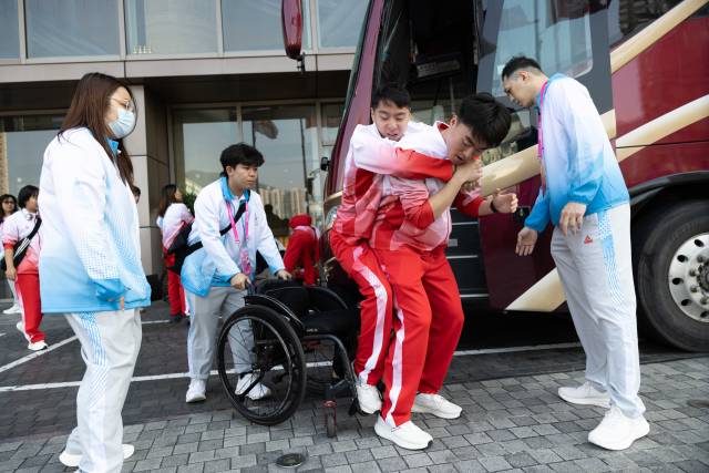 抵达香港酒店后,助教林琪深逐一将大巴上的队员背下来放置在轮椅上。
