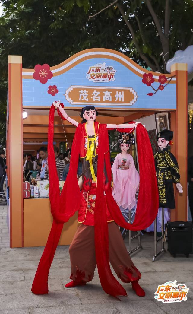 高州木偶戏在文明集市高州展位前展演。