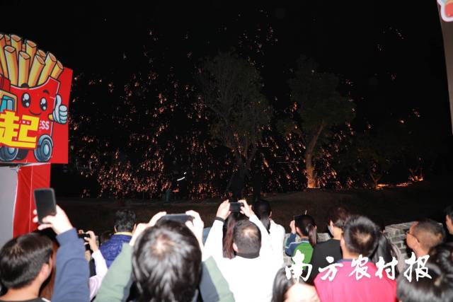 现场打铁花表演，吸引游客市民拍照围观。