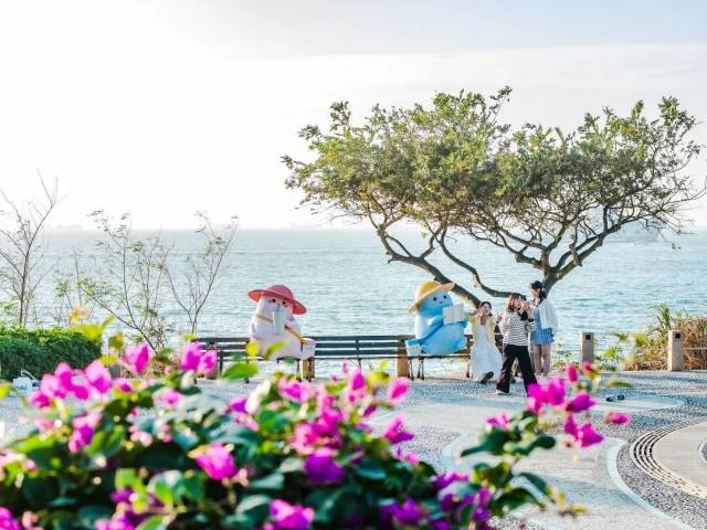 游客在桂山岛吉祥物“桂小白”的海边雕塑前拍照打卡（图：视觉中国）