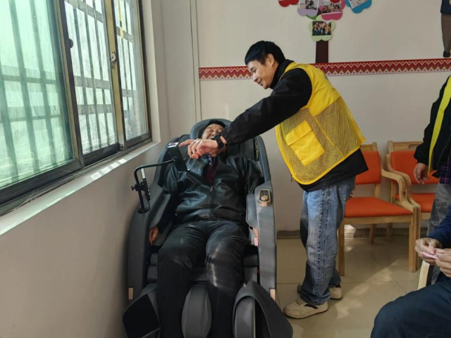 大竹湾村老人们使用按摩椅旁