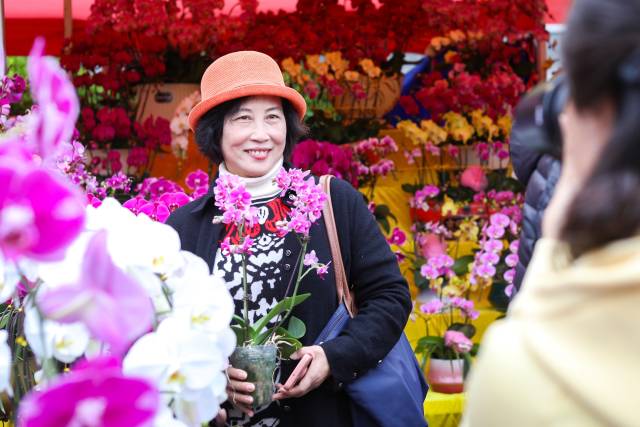 一位市民挑选到中意的花卉后，与花卉开心合照。