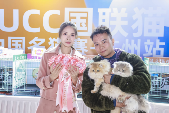 裁判（左）为获奖小猫颁发奖花。