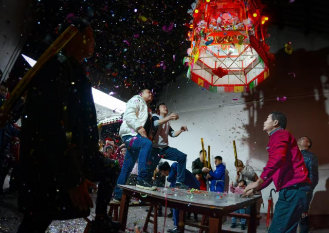 在爆竹齐鸣与族人祝福中，花灯升至上厅横梁。受访者供图