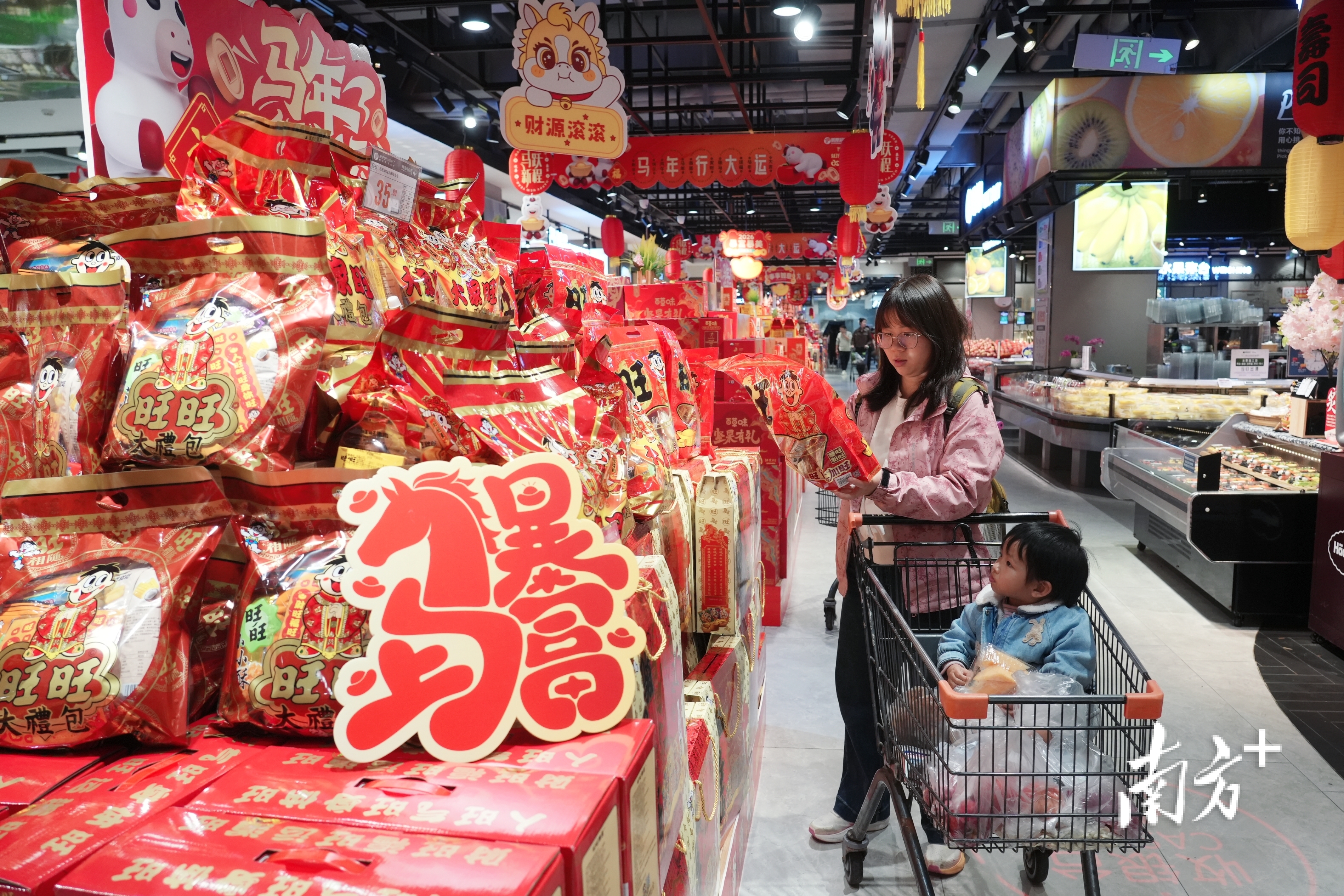 市民在超市年货柜台上选购货品。  