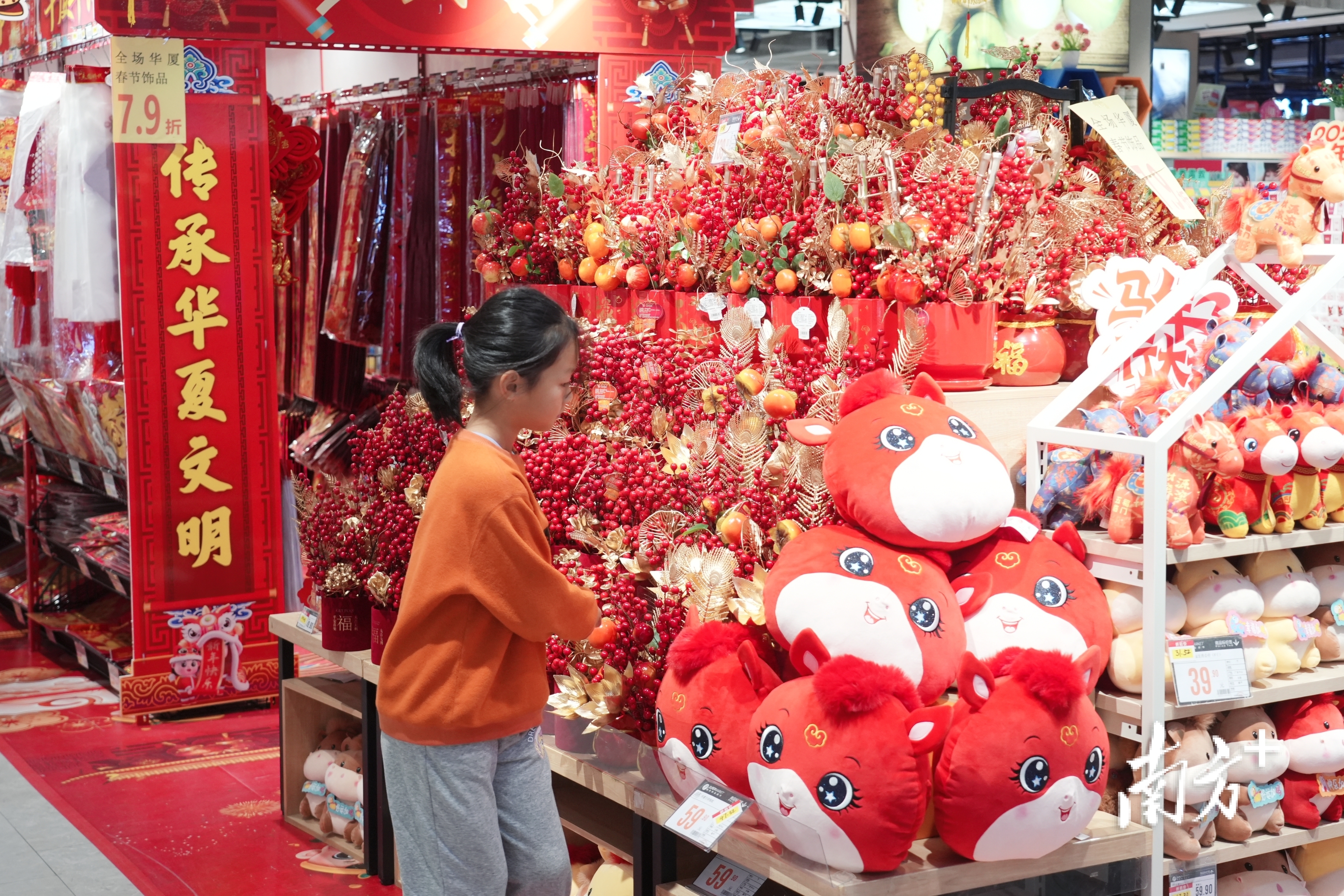 小朋友在年货柜台挑选装饰品。