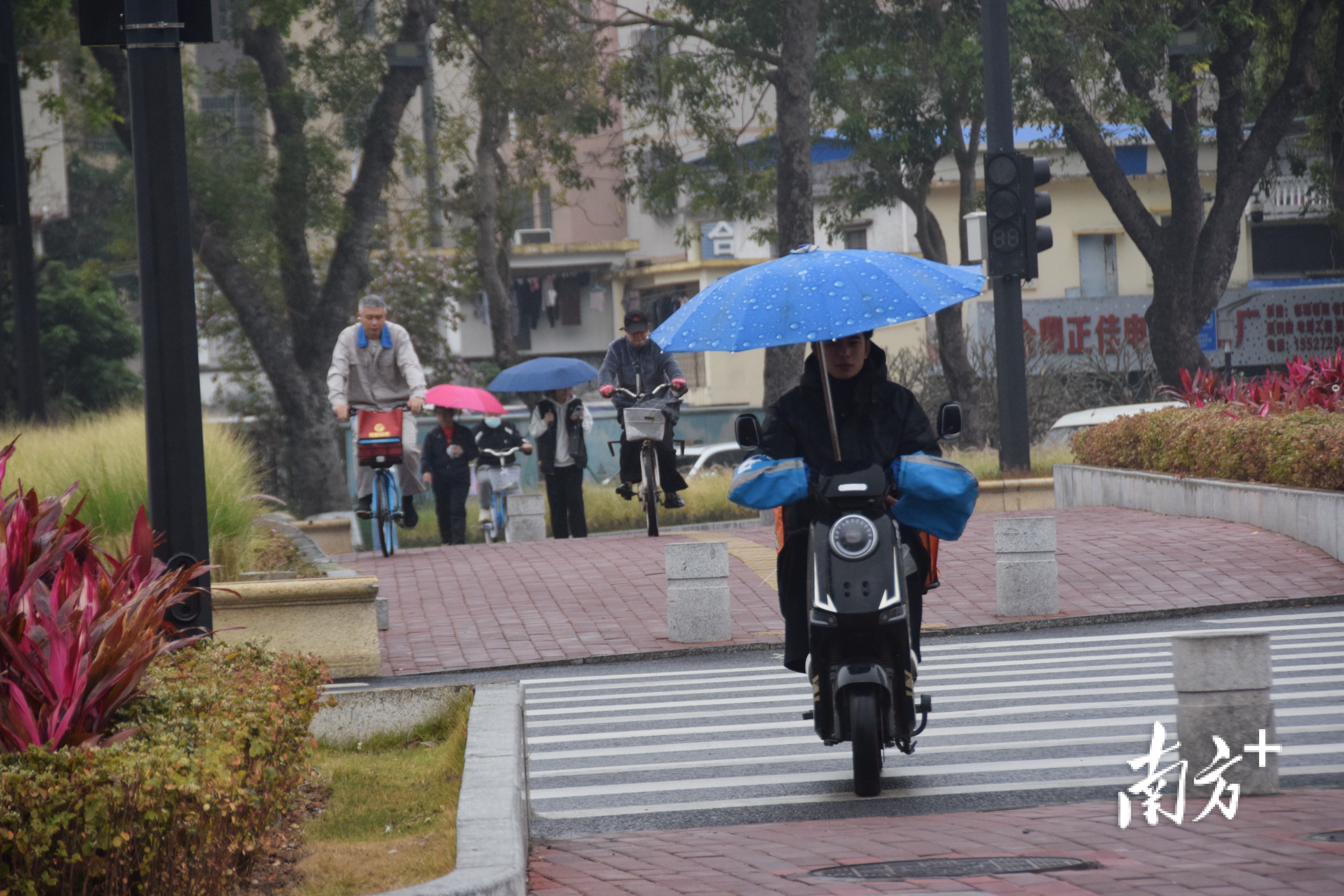 市民在雨中赶路。 