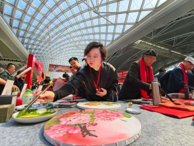 书法家们笔下生花，为旅客带来“文化年货”。