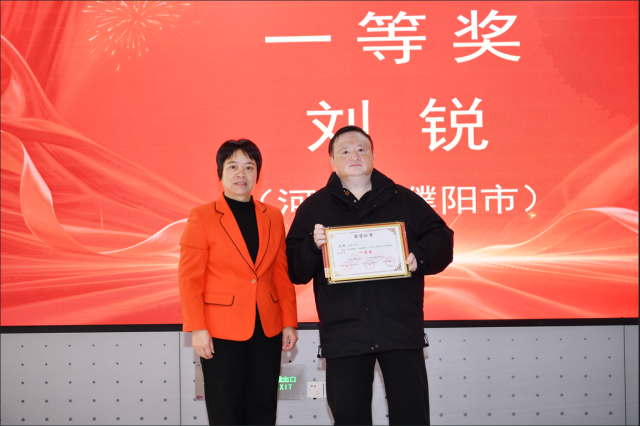 兴宁市委常委、宣传部部长罗丽思为一等奖获得者刘锐颁奖。  