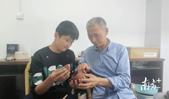 阿不都外力·艾萨在宜兴紫砂工艺美术师张宝余的指导下制作紫砂壶。