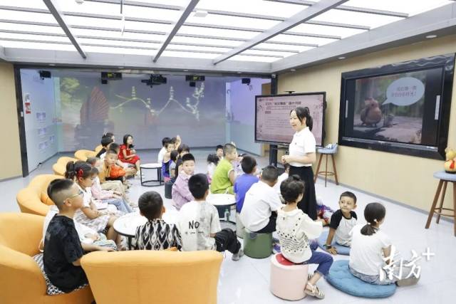 “悦读粤有趣”城市书吧中，工作人员向孩子们进行书籍讲解。