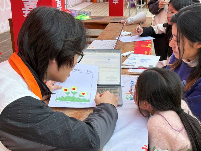 实践团队员利用“安心AI”绘画心理分析系统为学生解读画作