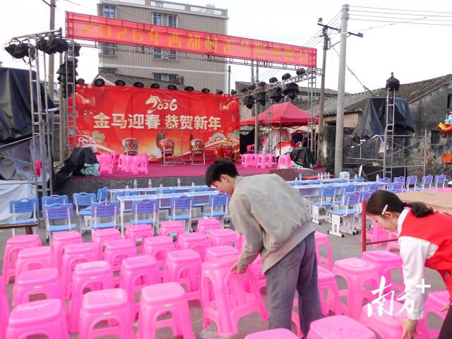 “村晚”开场前，大学生们在布置场地。