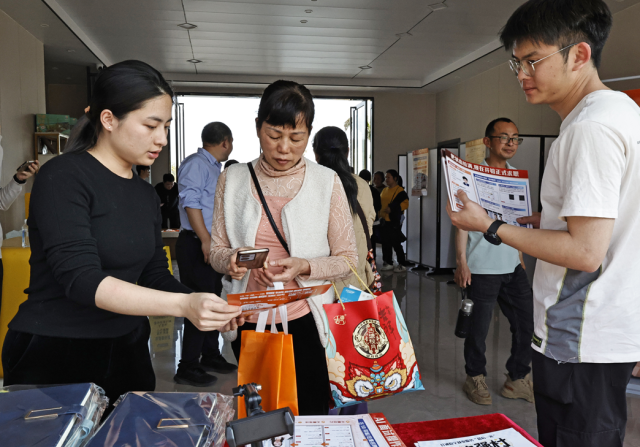 四都镇AI就业服务站，工作人员向村民介绍AI求职方式。