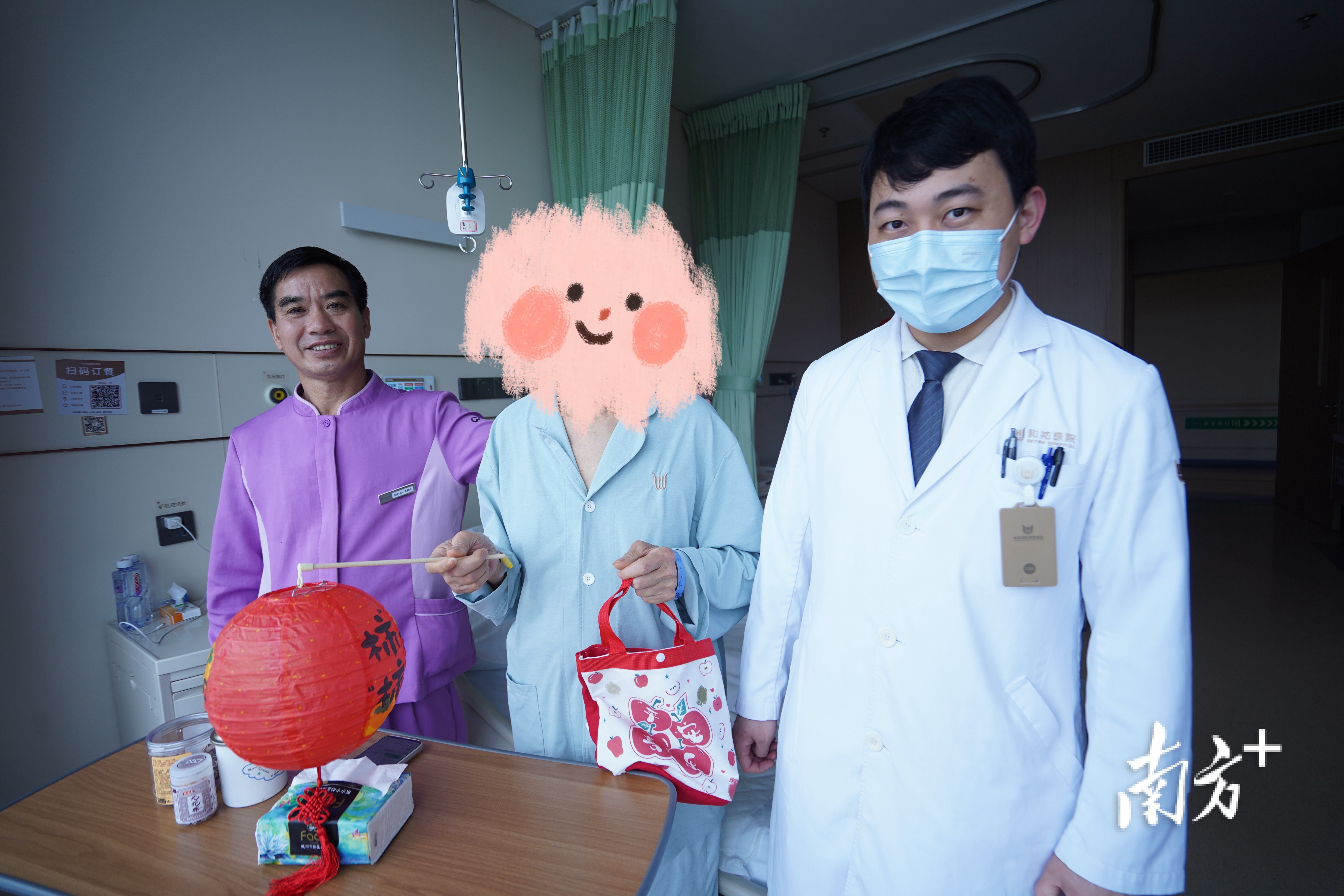 出院前，张老（中）获得和祐医院赠送的柿柿如意灯笼和元宵健康福袋。 南方+ 戴嘉信 摄