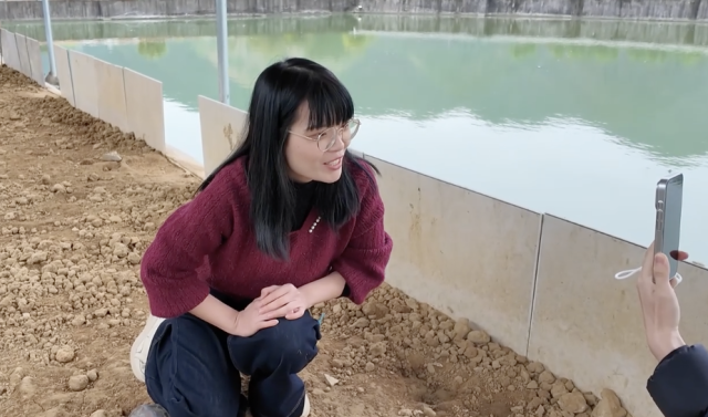 岑燕颖在龟塘旁拍摄短视频。