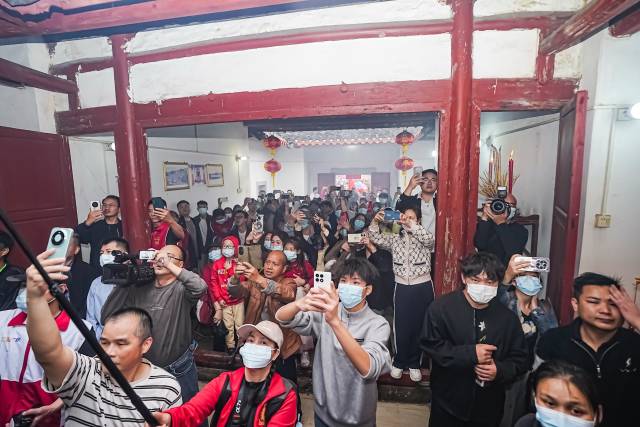 金星村升灯仪式现场，拍照记录的村民和游客挤满祖屋。