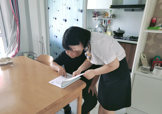 滁州分公司客服中心工作人员上门为老年客户讲解保险条款。