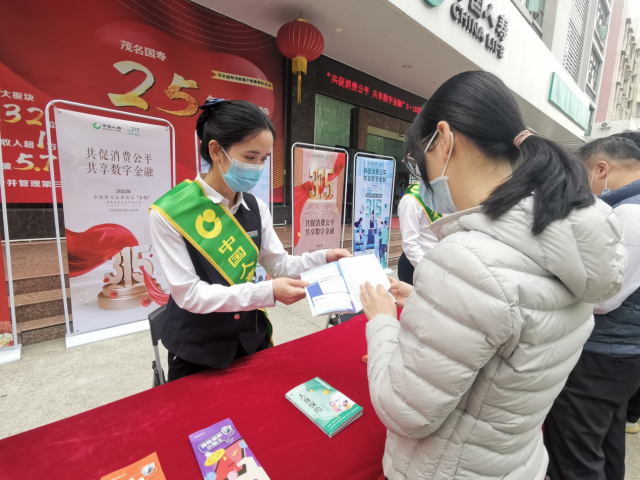 茂名分公司团体业务部工作人员为市民介绍普惠保险。
