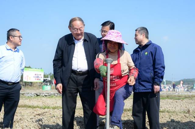 中国工程院院士罗锡文（左二）再次亲临封开春耕现场。