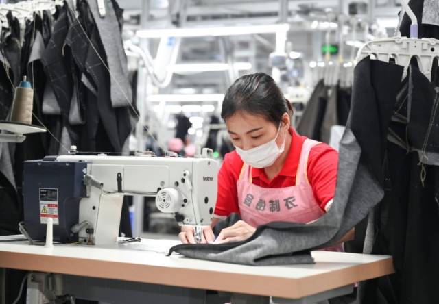 在金彭制衣的车间，一天可生产上万条裤子。