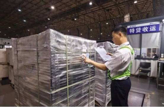 工作人员正对广东出口英国的荔枝进行检验。南方航空 供图