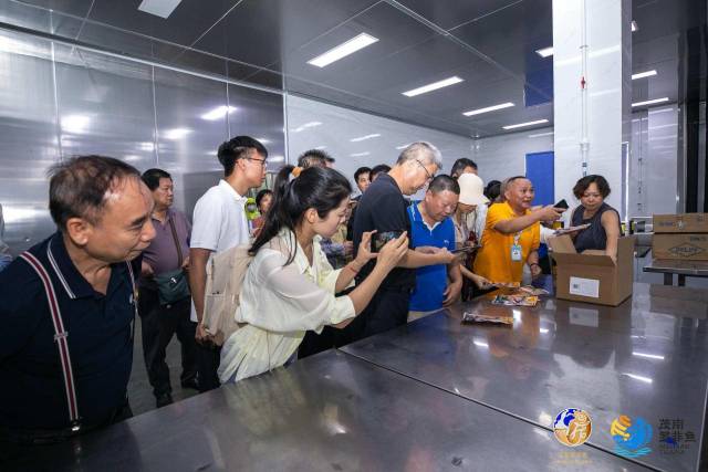 采购商对茂南罗非鱼加工产品十分感兴趣，一直在用手机拍摄记录。
