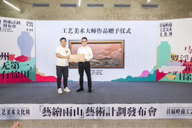 云浮市工艺美术行业协会会长杨桂龙（左）上台赠送石艺作品《徐田石韵》