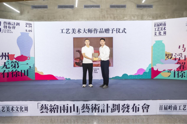 广轻置业党委委员、副总经理王海龙（左）上台赠送手拉壶作品《见龙在田》