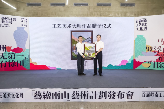 云浮市工业和信息化局四级调研员陈志明（左）上台赠送石艺作品《古宅书香》