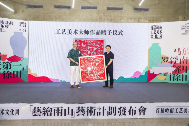 广东省工艺美术大师陈传生（左）上台赠送剪纸作品《徐田新韵》