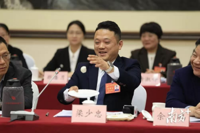 梁少忠在广东省两会现场用鱼丸“颠球”。