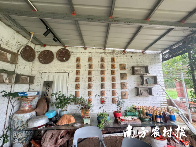 老房子剩下的旧瓦片，洗干净，用红漆描上陆游《游山西村》的诗句，一块一块嵌在院墙上。