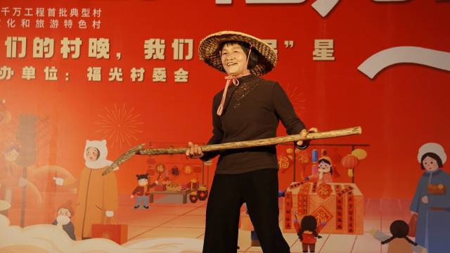 村民手持农具，在村晚舞台上走出了自信的步伐。