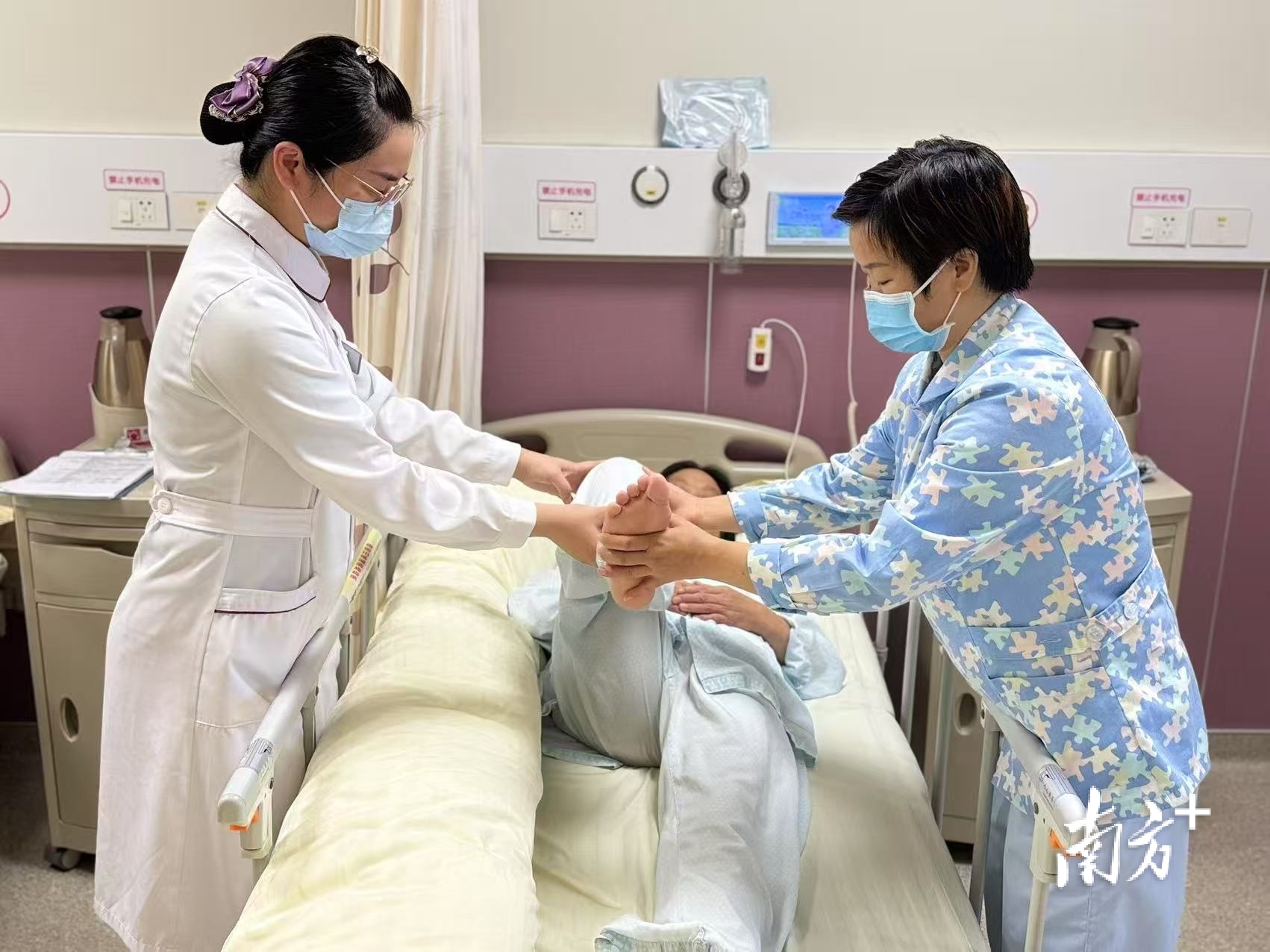 佛山市妇幼保健院试点病区内,护士指导护理员协助患者做康复训练。 受访单位供图