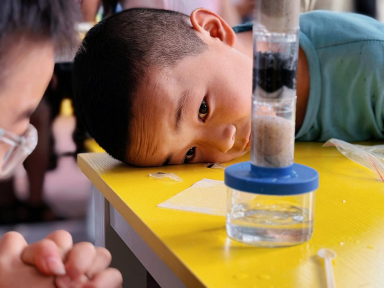 孩子凑近观察净水实验,清澈的水滴让他眼前一亮 孩子凑近观察净水实验,清澈的水滴让他眼前一亮