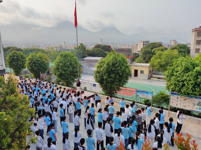 祠北小学正在举行升旗仪式,学生们眼前的是崭新的球场。 祠北小学正在举行升旗仪式,学生们眼前的是崭新的球场。