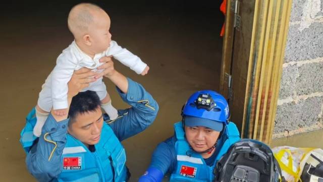 没过胸口的洪水中，他们将宝宝举过头顶