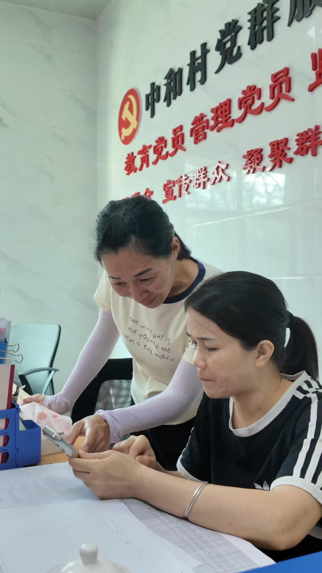 刘名芳(后)手把手教新任村干部处理业务。曾灿奎 摄 刘名芳(后)手把手教新任村干部处理业务。曾灿奎 摄