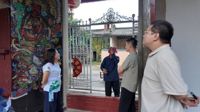 广东文艺职业学院师生与井新村村干部在老寨前交流，记录村庄变迁。