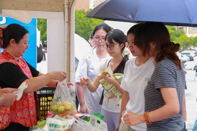 龙州的黄金百香果酸甜可口，俘获了众多学生的芳心。多名学生品尝后纷纷购买。